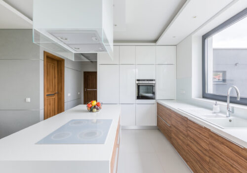 White,Kitchen,With,Island,,Long,Countertop,And,Wooden,Cupboards